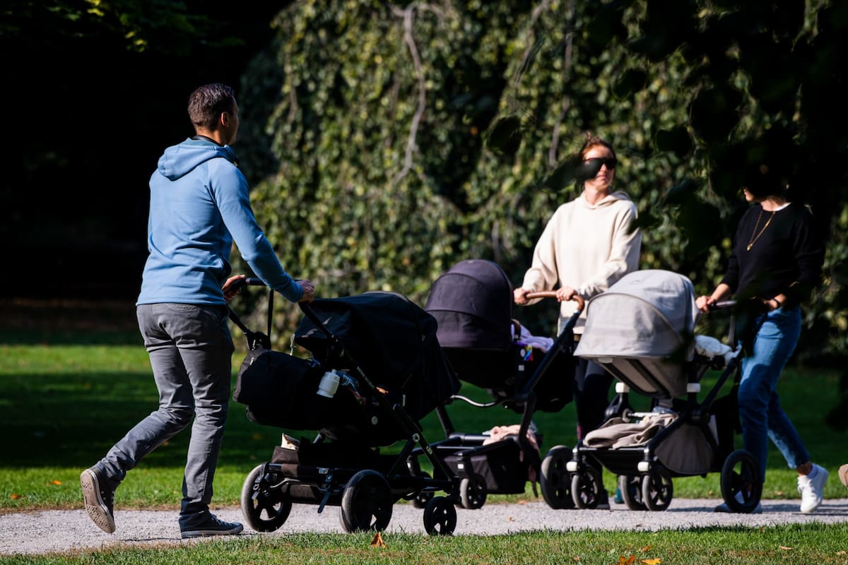 Un hombre pasea a su bebé en un cochecito en Humlegarden, en Estocolmo el 24 de septiembre de 2020