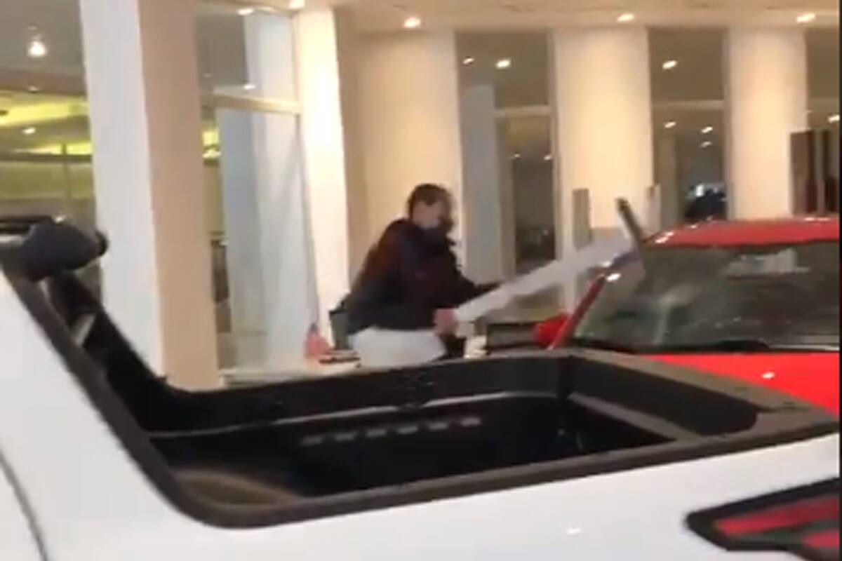 Un hombre rompe un auto en una concesionaria
