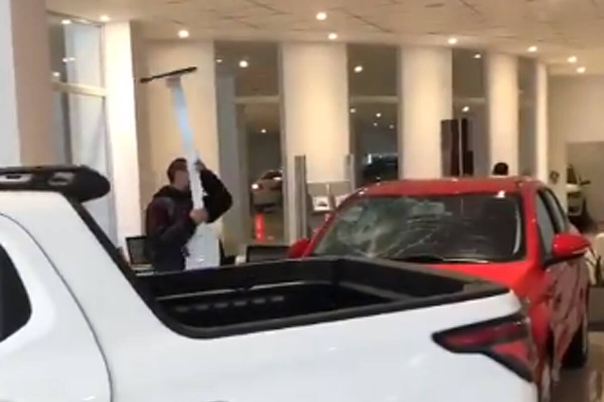 Un hombre rompe un auto en una concesionaria