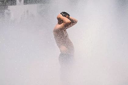 Un hombre se refresca en una fuente en Portland, Oregon; el calor asfixia a parte de Estados Unidos y Canadá
