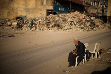 Un hombre se sienta en una silla junto a los escombros de un edificio derruido en la ciudad de Alejandreta, en el sur de Turquía, el martes 14 de febrero de 2023. (AP Foto/Francisco Seco)