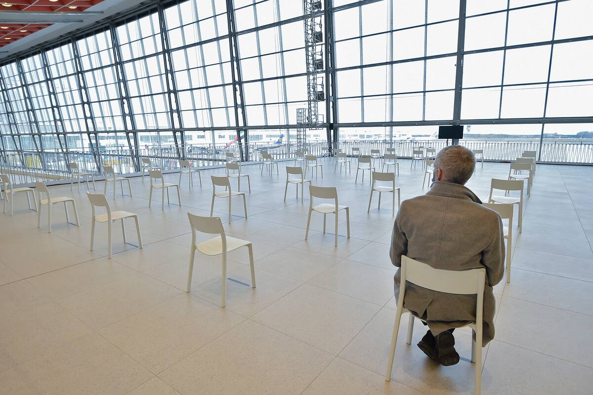 Un hombre sentado en una zona de descanso antes de recibir una inyección de la vacuna Covid-19 el día de la inauguración del centro de vacunación en el aeropuerto Zaventem Skyhall de Bruselas, en Zaventem, el 22 de febrero de 2021