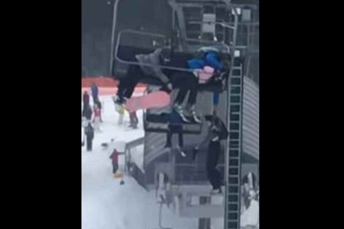 Un hombre sostiene a su hijo que quedó colgado de la aerosilla