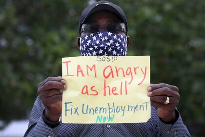 Un hombre sostiene un cartel en el que exige al gobierno de Estados Unidos que "arregle el desempleo ahora"