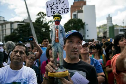 Un hombre sostiene una estatuilla del santo venezolano