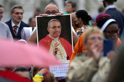 Un hombre sostiene una foto del papa Juan Pablo I durante una ceremonia de beatificación dirigida por el papa Francisco en la Plaza de San Pedro del Vaticano. (AP Foto/Andrew Medichini)