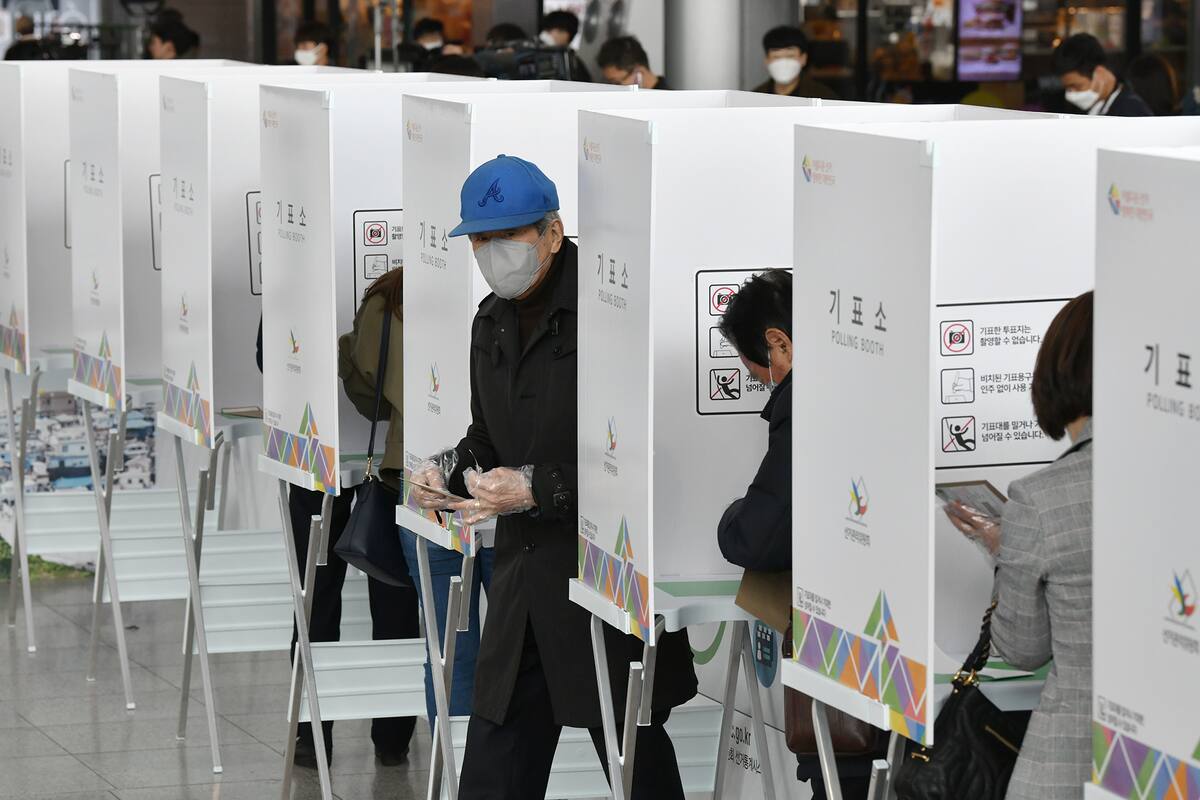 Un hombre surcoreano vota durante la votación anticipada en un colegio electoral en Seúl el 10 de abril de 2020