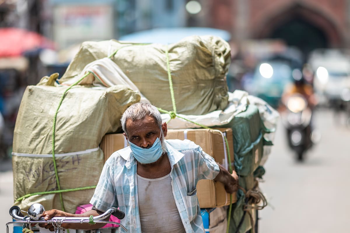 Un hombre tira de su rickshaw cargado a lo largo de una calle del casco antiguo de Nueva Delhi el 7 de agosto de 2020