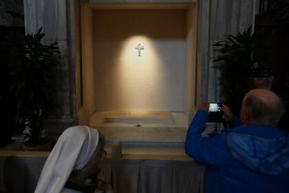 Un hombre toma fotos de la tumbra del papa Francisco tras la apertura de la basílica de Santa María la Mayor en Roma a los fieles en Roma, el domingo 27 de abril de 2025. (AP Foto/Alessandra Tarantino)