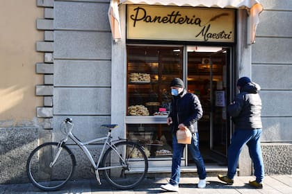 Un hombre usa barbijo a la salida de una panadería en Codogno, Italia