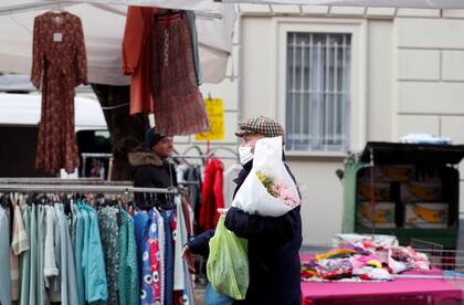 Un hombre utiliza un barbijo mientras camina por un mercado en Milán