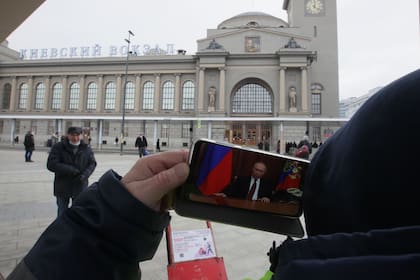 Un hombre ve en su teléfono la declaración de guerra del presidente ruso, Vladimir Putin, cuando decidió la invasión a Ucrania