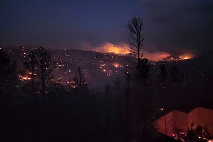 Un incendio arde en una colina en la ciudad de Ruidoso, Nuevo México, el 13 de abril de 2022. (Alexander Meditz vía AP)