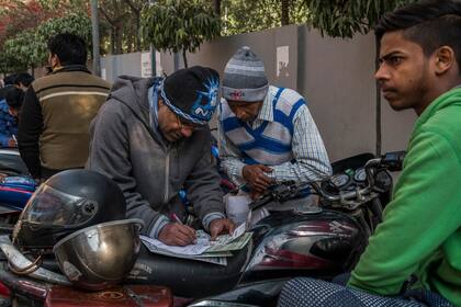 Un indio llena el formulario de registro para el sistema Aadhaar, en Nueva Delhi