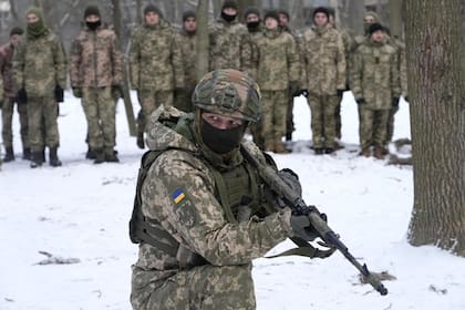 Un instructor entrena a miembros de las Fuerzas de Defensa Territorial de Ucrania, unidades militares voluntarias de las Fuerzas Armadas, en un parque de la ciudad de Kiev, Ucrania, el sábado 22 de enero de 2022.