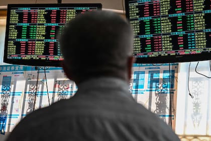 Un inversor monitorea los movimientos del precio de las acciones en una compañía de valores en Shanghai