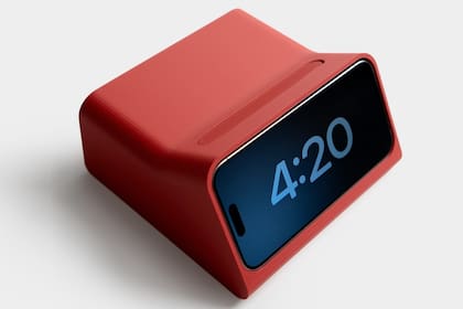 Un iPhone en modo StandBy con una base de carga; Apple prepara un nuevo dispositivo para controlar el hogar inteligente que usará algunos conceptos de StandBy, según Mark Gurman