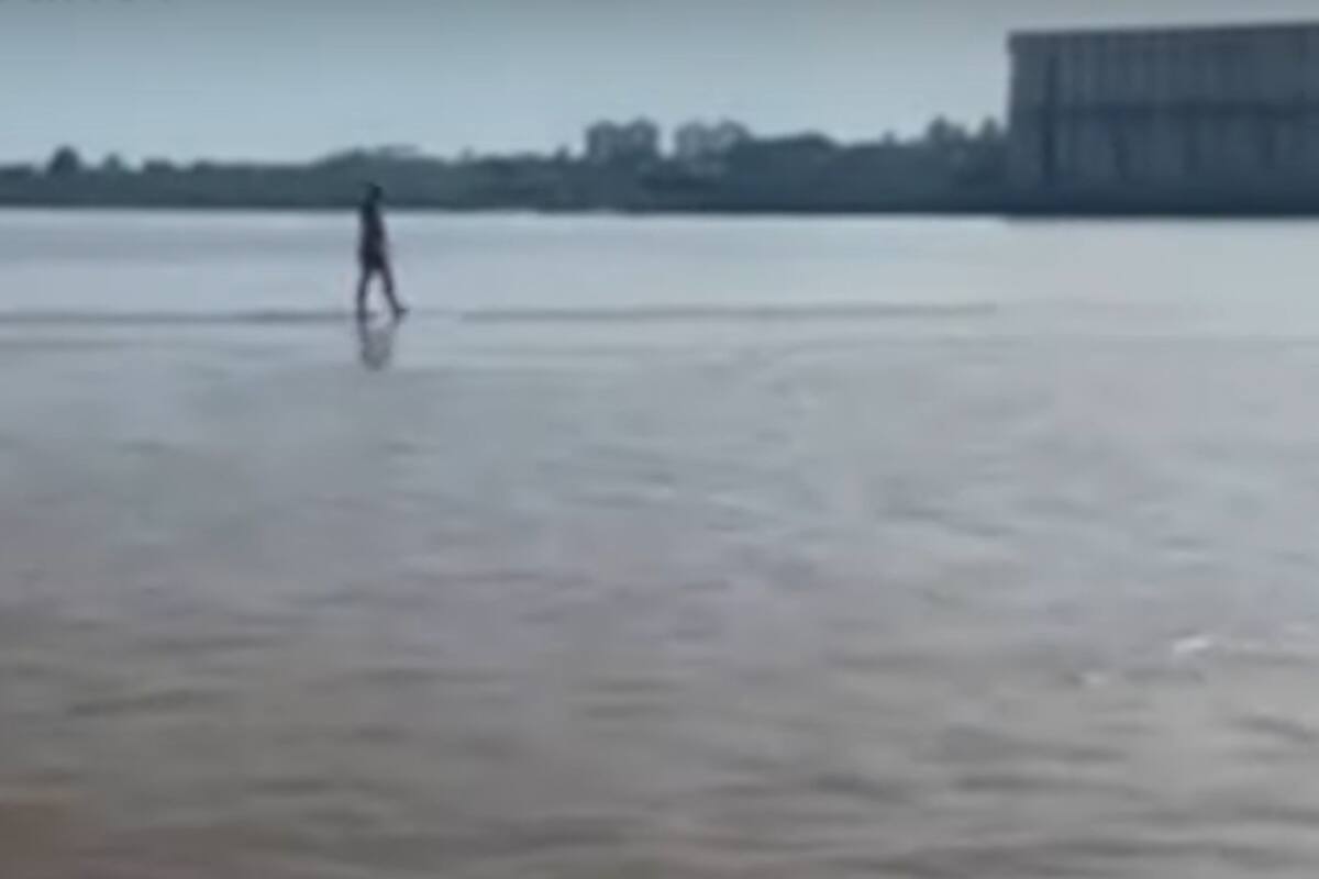 Un joven camina en el medio del río Paraná