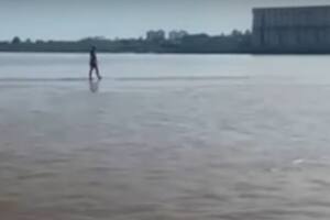 Un joven camina en el medio del río Paraná