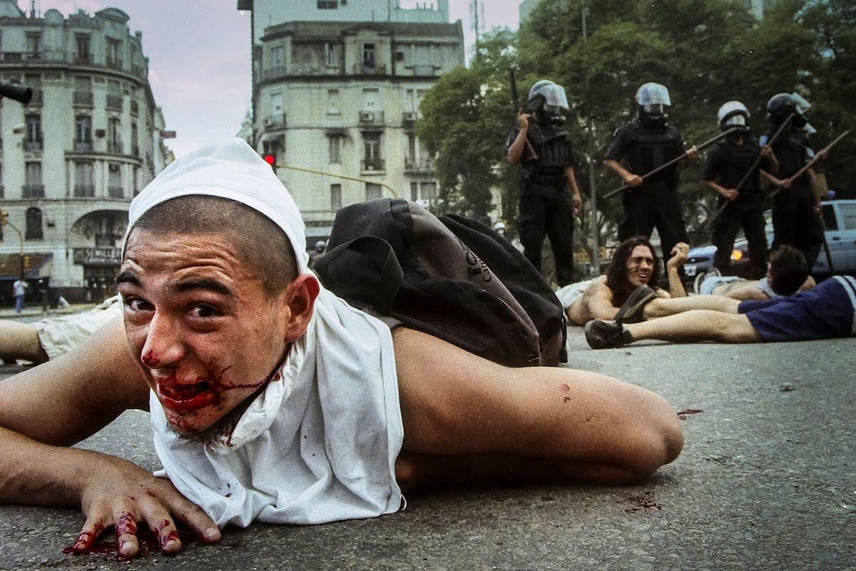 Un joven herido pide ayuda despues de ser detenido por la policía el 20 de diciembre de 2001, en Avenida 9 de Julio y Avenida de Mayo.