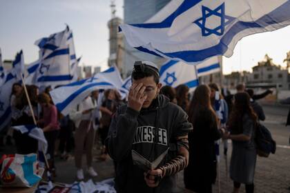 Un joven israelí reza junto a activistas de ultraderecha durante una protesta contra el primer ministro de Israel, Naftali Bennett, en medio de una reciente ola de violencia, en in Tel Aviv, Israel, el 30 de marzo de 2022. (AP Foto/Oded Balilty)