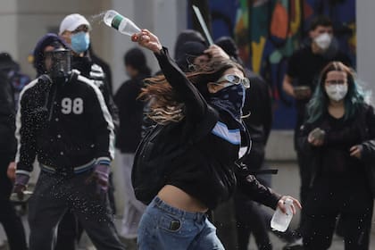 Un joven manifestante lanza una botella de plástico contra la policía antidisturbios durante los enfrentamientos en Tirana, Albania, el jueves 15 de octubre de 2026, cuando estudiantes se unieron a una manifestación antigubernamental