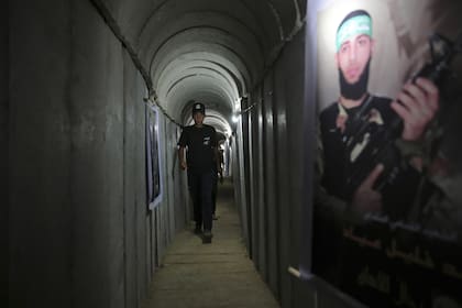 Un joven palestino camina dentro de un túnel utilizado para ejercicios militares durante una exposición de armas en un campamento de verano juvenil dirigido por Hamas en la ciudad de Gaza el 20 de julio de 2016. Un extenso laberinto de túneles construidos por Hamas se extiende a lo largo de los densos barrios de la Franja de Gaza , ocultando a militantes, su arsenal de misiles y a los rehenes que retienen después de un ataque sin precedentes el 7 de octubre de 2023 contra Israel.