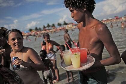 Un joven reparte caipirinhas, en el estanque artificial conocido como piscinao, o piscina grande, al norte de Río de Janeiro en Brasil.