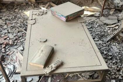 Un juego de mesa y un control remoto derretido, ambos cubiertos de polvo, capturan cómo la vida cotidiana en el kibutz se vio interrumpida de repente