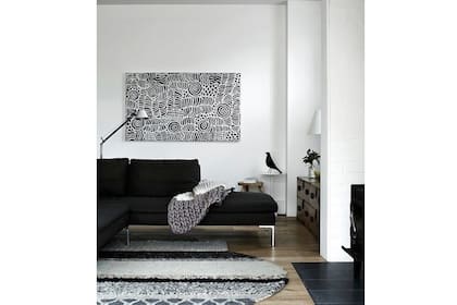 Un juego sutil de estampas en blanco y negro revisten la alfombra central de este living moderno