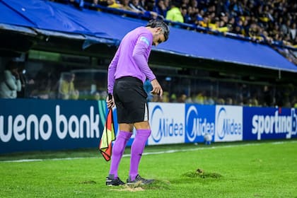 Un juez de línea trata de acomodar el césped de la Bombonera en el primer partido como local tras el Mundial, por la ida ante O'Higgins por la Copa Sudamericana