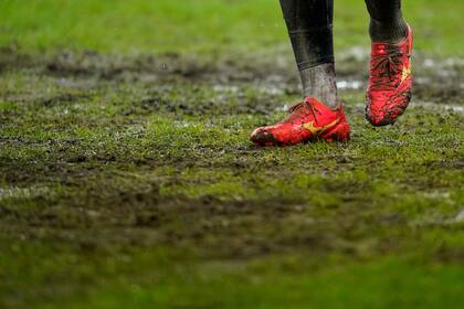 Un jugador camina sobre la cancha enfangada, antes del partido que terminó suspendiéndose, entre Saarbrücken y el Borussia Mönchengladbach, el miércoles 7 de febrero de 2024 (Uwe Anspach/dpa via AP)
