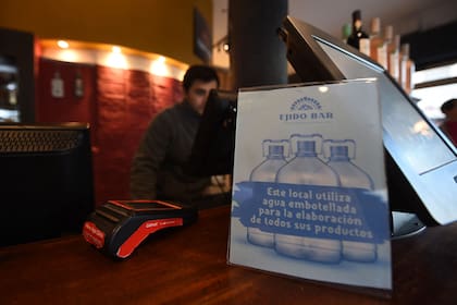 Un letrero para los clientes dice "Este negocio utiliza agua potable embotellada para elaborar todos sus productos" en un restaurante en Montevideo el 10 de julio de 2023, en medio de una severa sequía que provocó una crisis de agua en el país.  (Foto por Dante FERNANDEZ / AFP)