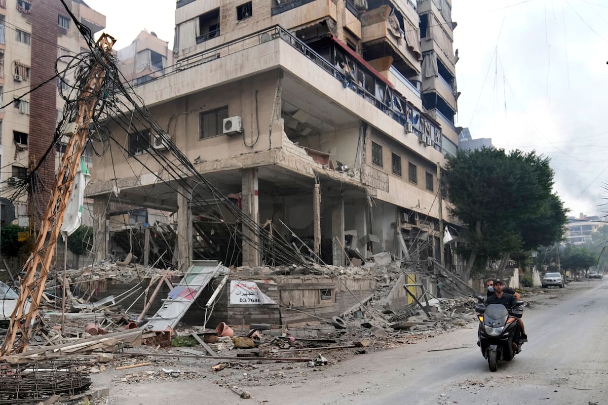 Un libanés pasa en motocicleta junto a un edificio dañado en un ataque israelí, en Dahiyeh, a las afueras de Beirut, Líbano, el 7 de octubre de 2024. (AP Foto/Hussein Malla)