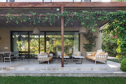 Un lugar para estar: la parrilla, una mesa donde comer, sillones para descansar. Todo sucede en esta galería dominada por la passiflora roja