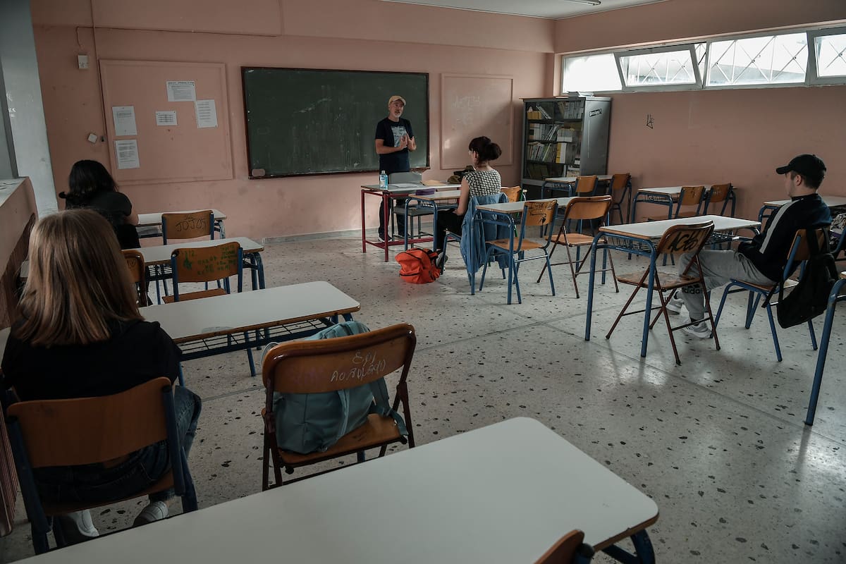 Un maestro habla con los estudiantes de último año en un aula de una escuela secundaria en Atenas el 11 de mayo de 2020 cuando Grecia reabrió las escuelas después de 2 meses desde su cierre debido a la pandemia de coronavirus
