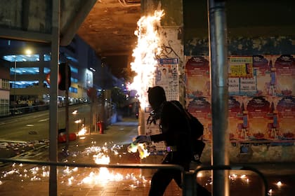 Un manifestante arroja una bomba molotov, ayer, en Hong Kong