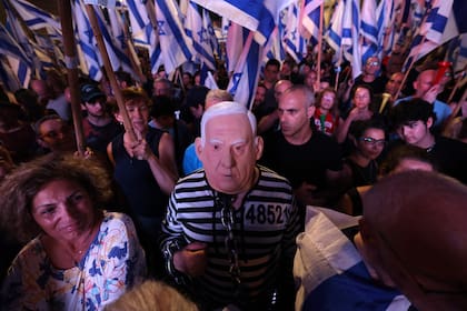 Un manifestante disfrazado con un traje a rayas y la máscara del primer ministro israelí, Benjamin Netanyahu, en una protesta contra la reforma judicial en Tel Aviv, el 15 de julio. (AHMAD GHARABLI / AFP)