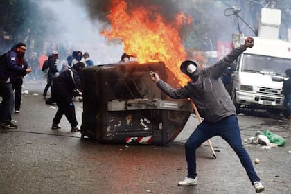 Un manifestante lanza piedras a la policía en la Plaza del Congreso, mientras sesionaban los diputados