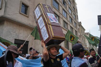 Un manifestante lleva un ataúd falso con la foto del presidente interino José Jeri después de que el Congreso votara su destitución