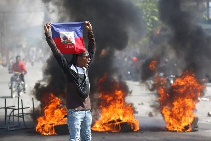 Un manifestante muestra una bandera haitiana durante una protesta para exigir la renuncia del primer ministro del país, Ariel Henry, en Puerto Príncipe, Haití, el 1 de marzo de 2024