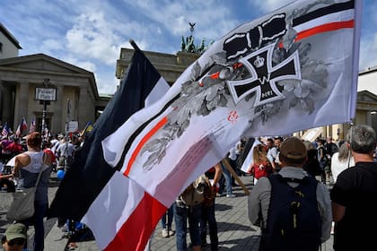 Un manifestante ondea una bandera del antiguo Imperio Alemán durante una manifestación convocada por la extrema derecha en Berlín.