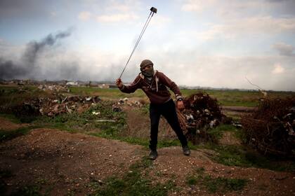 Un manifestante palestino sostiene un cabestrillo mientras posa para una fotografía en la escena de los enfrentamientos con las tropas israelíes cerca de la frontera con Israel, al este de la ciudad de Gaza