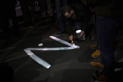 Un manifestante pinta la letra "Z" en una calle de Belgrado durante una manifestación organizada por organizaciones derechistas serbias en apoyo de la invasión rusa en Ucrania