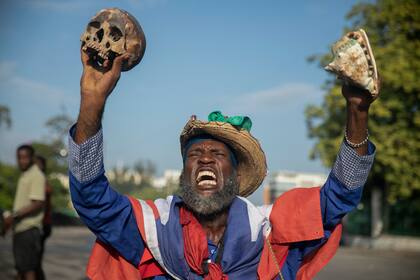 Un manifestante que sostiene una calavera y una concha de mar exige a gritos la renuncia del primer ministro haitiano Ariel Henry, el lunes 17 de octubre de 2022, en Puerto Príncipe, Haití. (AP Foto/Odelyn Joseph)