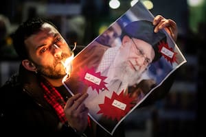 Un manifestante quema una foto del ayatollah Ali Khamenei durante una manifestación en apoyo de las masivas protestas antigubernamentales en Irán, el 13 de enero de 2026 en Zúrich, Suiza