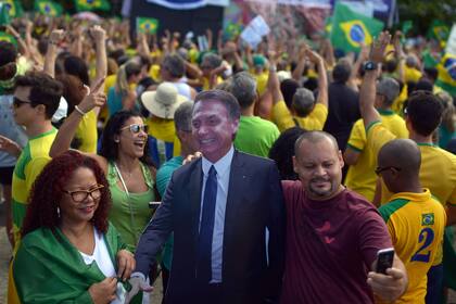 Un manifestante se saca una selfie con una imagen de Bolsonaro, cerca de Copacabana
