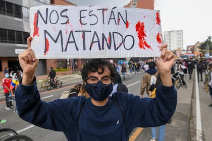 Un manifestante sostiene un cartel que dice 'Nos están matando' durante una protesta contra una reforma tributaria propuesta por el gobierno del presidente colombiano Iván Duque en Bogotá, el 4 de mayo de 2021