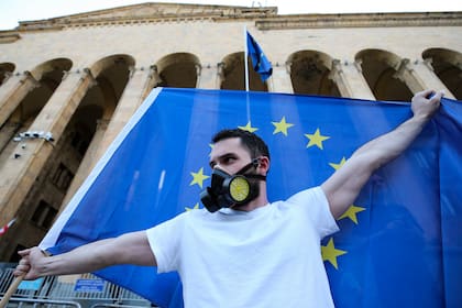 Un manifestante sostiene una bandera de la Unión Europea mientras participa en una protesta fuera del Parlamento, el miércoles 17 de abril de 2024, en Tiflis, Georgia. (AP Foto/Zurab Tsertsvadze)