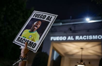 Un manifestante sostiene una imagen de Vinicius Junior con un mensaje en portugués que se traduce: "Pelea contra el racismo"